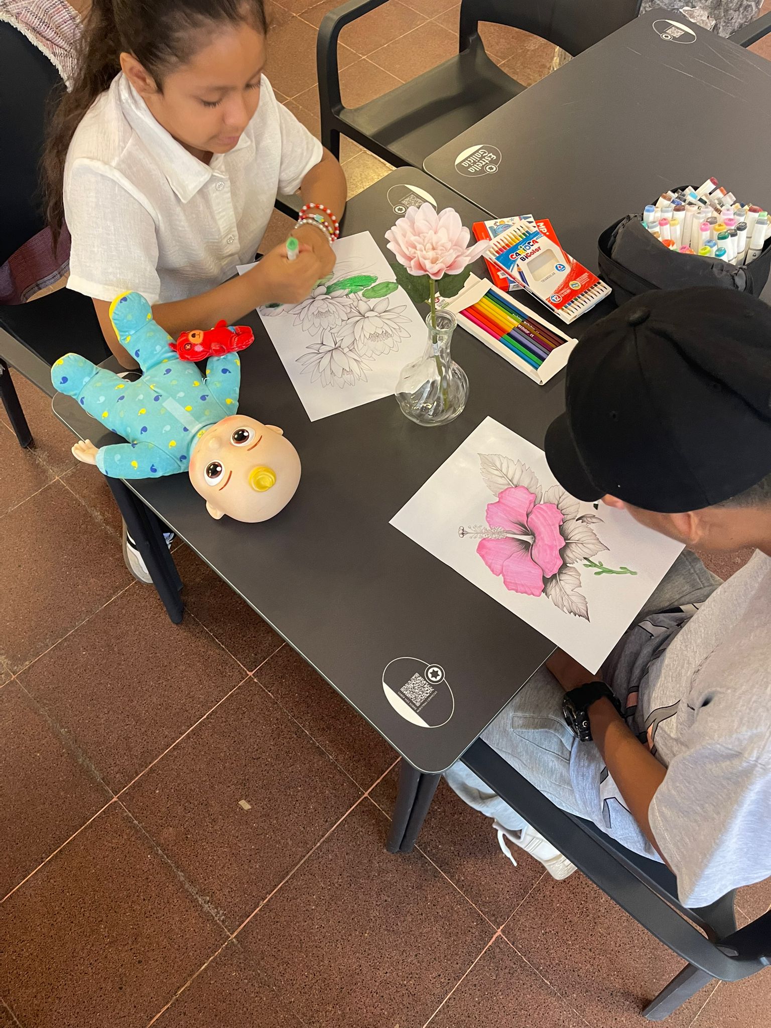Participantes concentrados dibujando sus flores